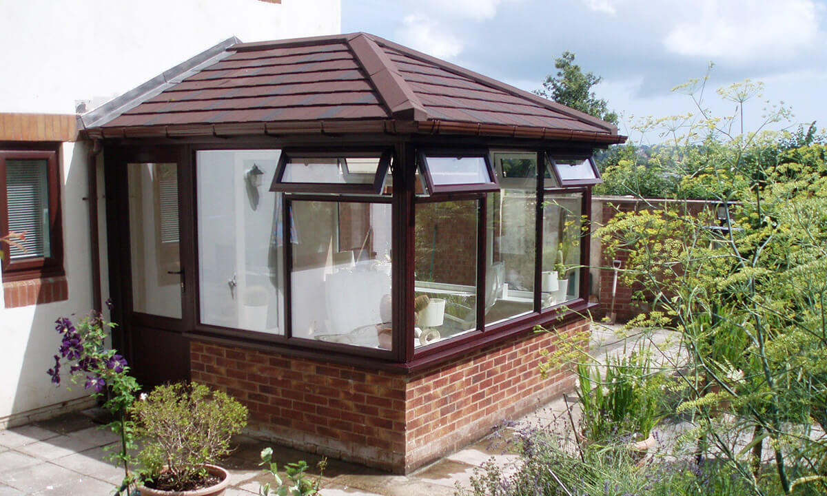 Rosewood effect uPVC conservatory with a red tiled roof - paignton